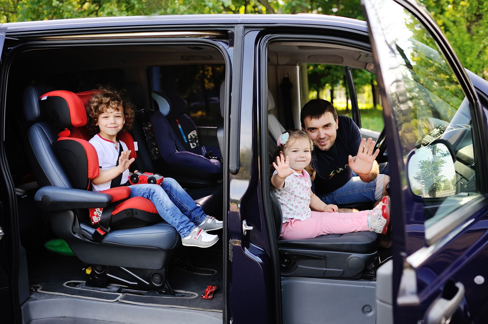 Famille installée dans un minivan avec des sièges enfants