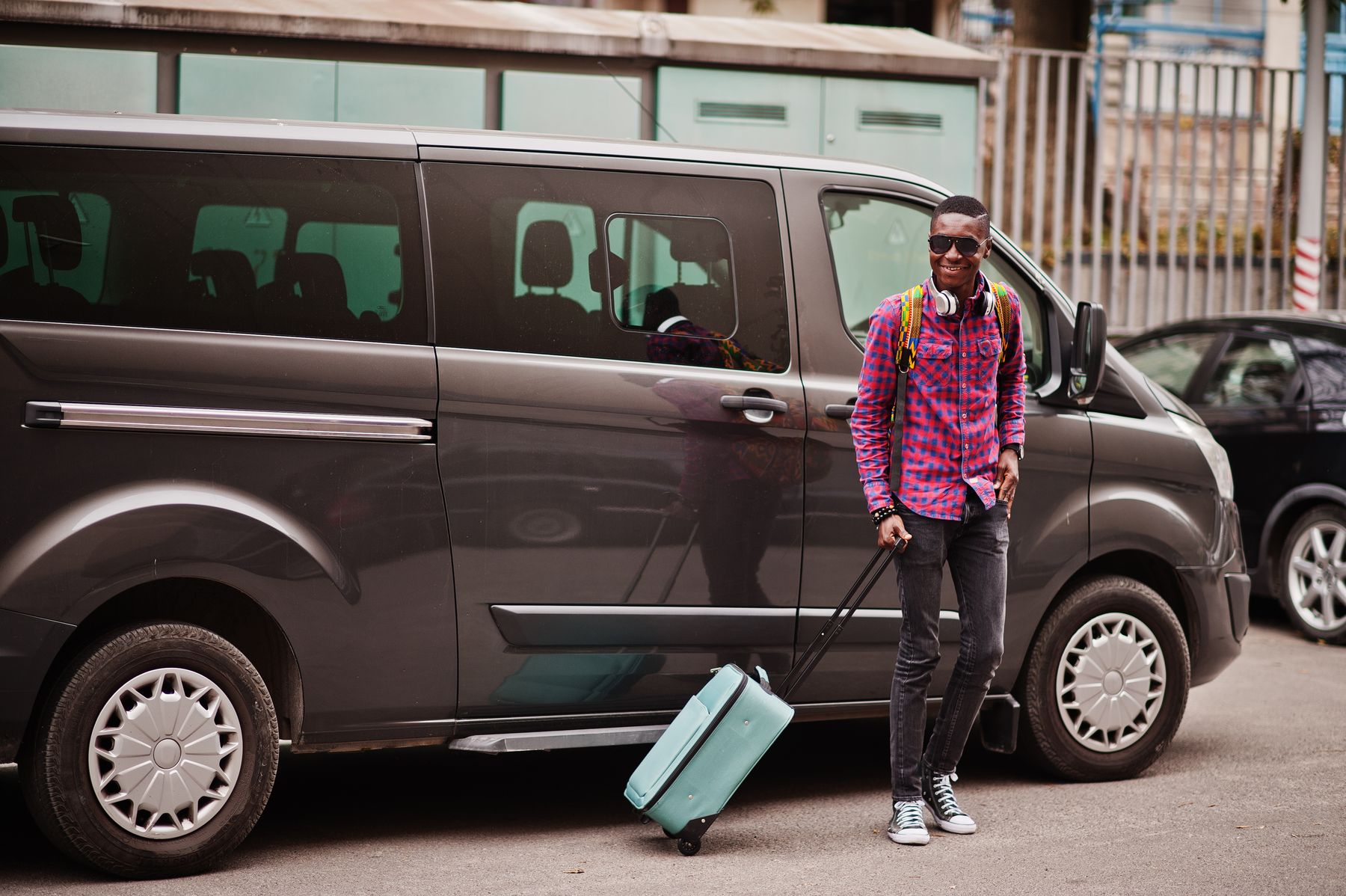Voyageur avec sa valise à côté d’un minibus